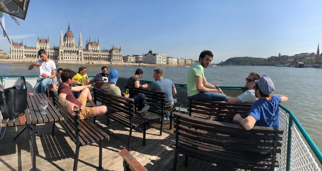 à un enterrement de vie de garçon à Budapest sur un bateau privé avec open bar sur le Danube avec le parlement hongrois en arrière-plan